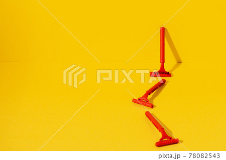 Disposable razors on yellow background, studio shot Disposable razors on yellow background, studio shot 78082543