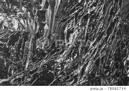Black glued crumpled shiny grunge plastic. Wrinkled polyethylene film. Abstract background Black glued crumpled shiny grunge plastic. Wrinkled polyethylene film. Abstract background 78082734