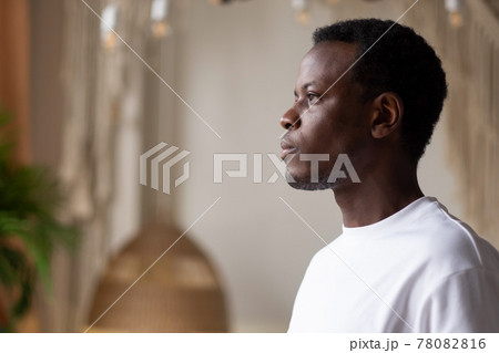 African man standing at home alone planning future day African man standing at home alone planning future day 78082816