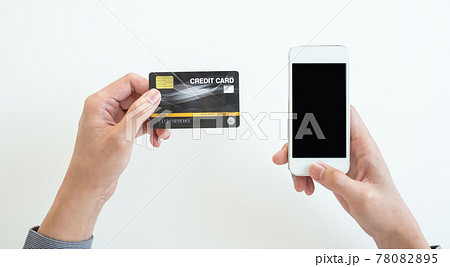 The businessman's hand is holding a credit card and using a smartphone for online shopping and internet payment in the office The businessman's hand is holding a credit card and using a smartphone for online shopping and internet payment in the office 78082895