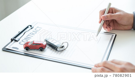 Car dealer businessman signing car insurance document or lease paper. Car loan and insurance concept Car dealer businessman signing car insurance document or lease paper. Car loan and insurance concept 78082901