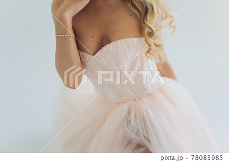 Charming bridesmaid dress with a delicate bow, rhinestones, embroidery and shiny beads close-up. Charming bridesmaid dress with a delicate bow, rhinestones, embroidery and shiny beads close-up. 78083985