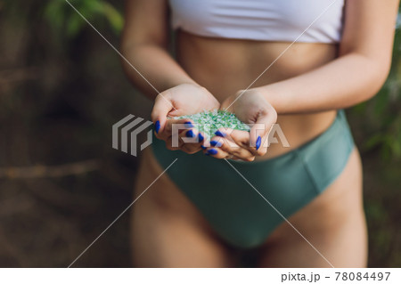 Tiny pieces of plastic collected from sandy beach in hands of environmentalist. Microplastic is polluting the sea and marine ecosystem. 78084497