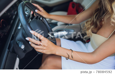 Close-up of a woman's hand on steering wheel in a modern car. Close-up of a woman's hand on steering wheel in a modern car. 78084592