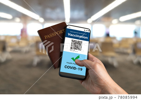 Traveler holds vaccine passport certificate to show COVID 19 vaccination status 78085994
