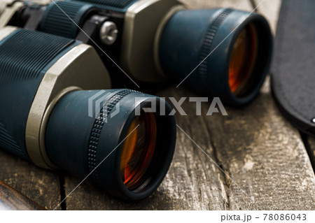 Hunting equipment binoculars on wooden background close up Hunting equipment binoculars on wooden background close up 78086043