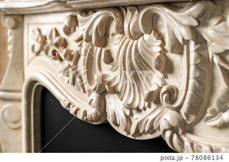 Carved patterns on stone luxury fireplace close up Carved patterns on stone luxury fireplace close up 78086134