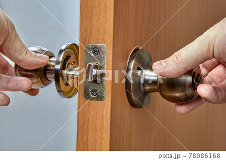 Assembling lock with door knobs and latch in living room. 78086168