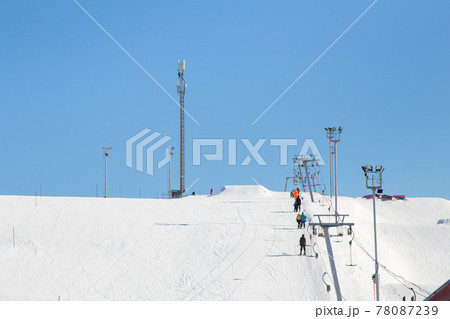 Ski resort, gentle snow slope with people on the lift going to the top. 78087239