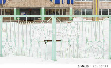 Wide iron gates with light green metal figures of people. Wide iron gates with light green metal figures of people. 78087244