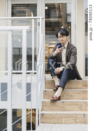 スマホの画面を見る若い男性 78090113