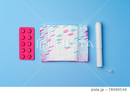 Contraceptive pills, hygienic pads and tampons on blue background 78090540