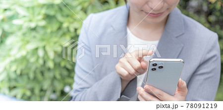 公園でスマホを操作する若い女性　バナーサイズ 78091219