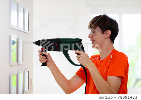 Man drilling wall. Home renovation and decoration. Man drilling wall. Home renovation and decoration. 78091423