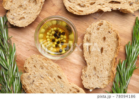 slice of whole meal bread and olive oil on table  slice of whole meal bread and olive oil on table  78094186