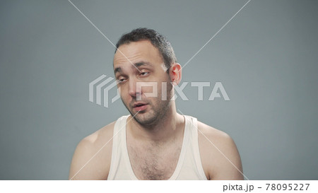 Photo of tired bristly man on gray background Photo of tired bristly man on gray background 78095227