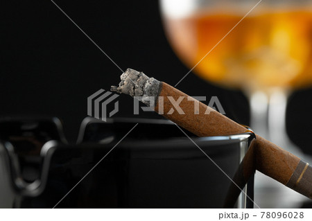 Close up of smoking cigar and whiskey glass on table Close up of smoking cigar and whiskey glass on table 78096028