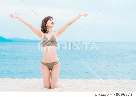 砂浜で膝立ちする水着の女性 砂浜で膝立ちする水着の女性 78096273