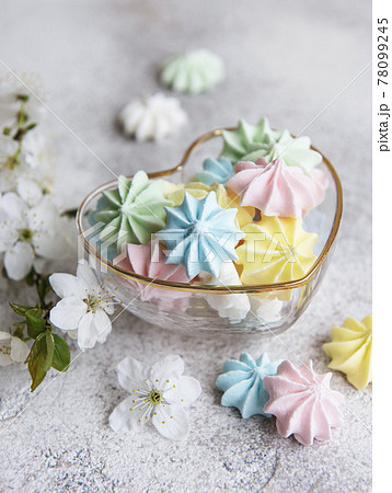 Small colorful meringues in the heart shaped bowl Small colorful meringues in the heart shaped bowl 78099245