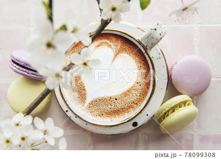 Coffee with a heart-shaped pattern and sweet macaroons desserts Coffee with a heart-shaped pattern and sweet macaroons desserts 78099308