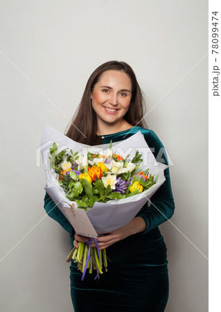Cute smiling woman holding flowers on white background Cute smiling woman holding flowers on white background 78099474