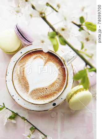 Coffee with a heart-shaped pattern and sweet macaroons desserts Coffee with a heart-shaped pattern and sweet macaroons desserts 78099700