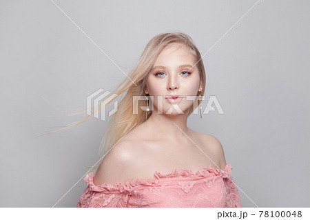 Gentle young woman with blonde hair and pearls earrings on white background Gentle young woman with blonde hair and pearls earrings on white background 78100048