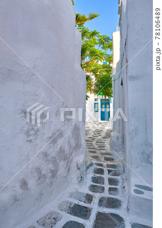 Traditional narrow cobblestone streets, beautiful alleyways of Greek island towns. Whitewashed walls, houses, blue doors. Summer. Mykonos, Greece 78106489