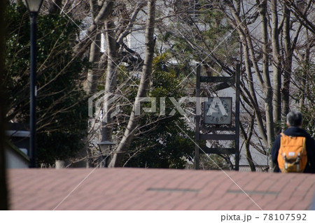 公園の歩道橋から見える時計と渡るオレンジのデイパックを背負った人物 公園の歩道橋から見える時計と渡るオレンジのデイパックを背負った人物 78107592