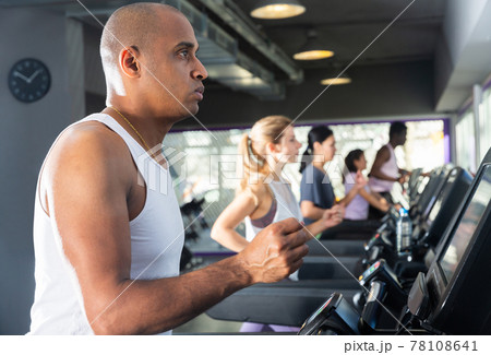 Man running on a treadmill in sports club 78108641