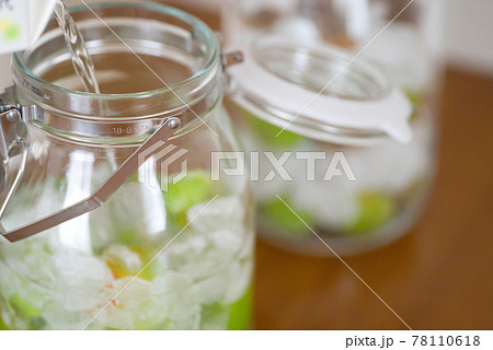 梅酒作り|ビンの容器にホワイトリカーを注ぐ 梅酒作り|ビンの容器にホワイトリカーを注ぐ 78110618