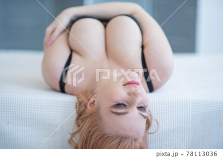 A beautiful blonde lies on her back and clutches her very large natural breasts with her hands. Young European woman in black underwear in the bedroom on the bed demonstrating a beautiful figure. A beautiful blonde lies on her back and clutches her very large natural breasts with her hands. Young European woman in black underwear in the bedroom on the bed demonstrating a beautiful figure. 78113036