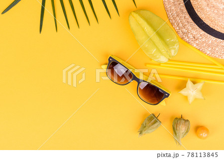 Fruit carambol, beach accessories and foliage of a tropical plant on colored paper Fruit carambol, beach accessories and foliage of a tropical plant on colored paper 78113845