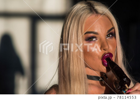 Woman with sensual lips holding dick lollipop. Blonde sucks a lollipop for adults. 78114553