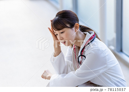 病院内でしゃがみこむ医師の女性 病院内でしゃがみこむ医師の女性 78115037