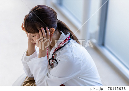 病院内でしゃがみこむ医師の女性 78115038