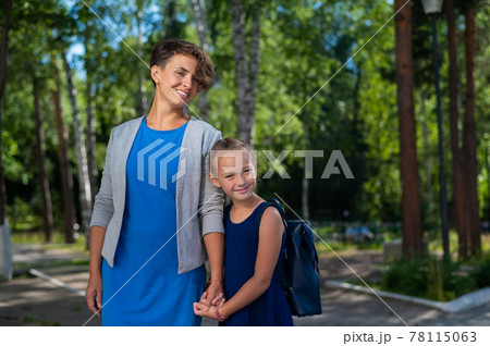 A Caucasian woman with short hair holds her daughter, a schoolgirl, by the hand A Caucasian woman with short hair holds her daughter, a schoolgirl, by the hand 78115063