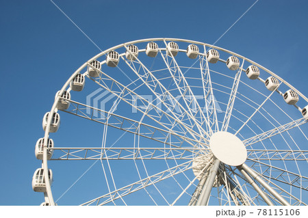 Part of a white Ferris wheel against a blue sky in summer day. Part of a white Ferris wheel against a blue sky in summer day. 78115106