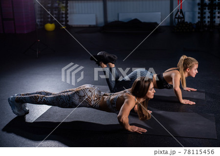 Female trainer teaches ward to do push-ups correctly. Beautiful woman trainer makes sure that her client, a young blonde, performs the exercises correctly. Push-ups from the knees. Personal training Female trainer teaches ward to do push-ups correctly. Beautiful woman trainer makes sure that her client, a young blonde, performs the exercises correctly. Push-ups from the knees. Personal training 78115456