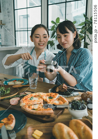 デジカメで食卓の料理写真を撮る女性 78115506