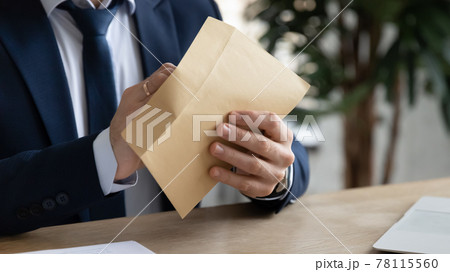 Hands of businessman opening paper envelope, taking out letter Hands of businessman opening paper envelope, taking out letter 78115560