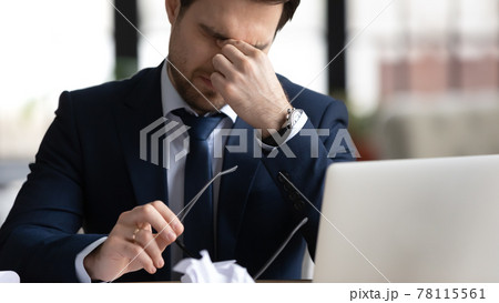 Stressed office employee touching dry irritable eyes Stressed office employee touching dry irritable eyes 78115561