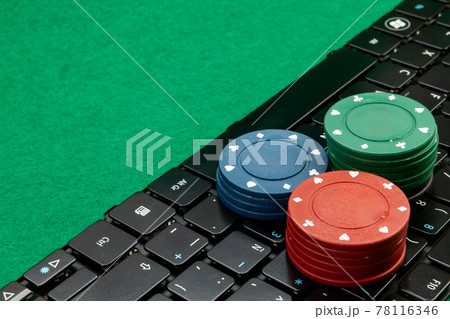 Gambling chips on computer keyboard on green background Gambling chips on computer keyboard on green background 78116346