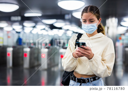 Woman in face mask enter in subway through turnstile Woman in face mask enter in subway through turnstile 78116780