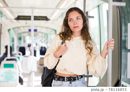 Young positive woman traveling in tram Young positive woman traveling in tram 78116855