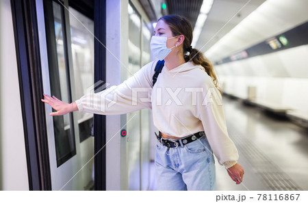 Confident girl in a protective mask in the subway is about to enter the train 78116867
