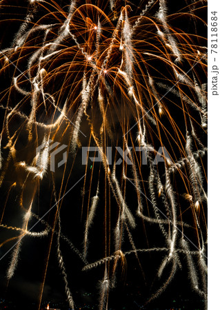 夜空にらせん状に散りゆく花びらのような花火の写真素材