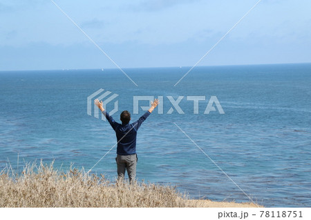 海と空に向かって両手を広げる男性のうしろ姿 海と空に向かって両手を広げる男性のうしろ姿 78118751