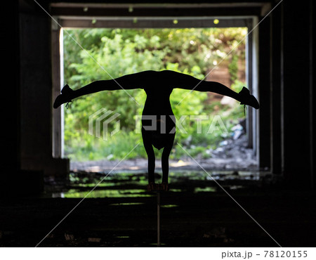 Silhouette of flexible circus artist doing handstand. Concept of individuality, creativity and outstanding Silhouette of flexible circus artist doing handstand. Concept of individuality, creativity and outstanding 78120155