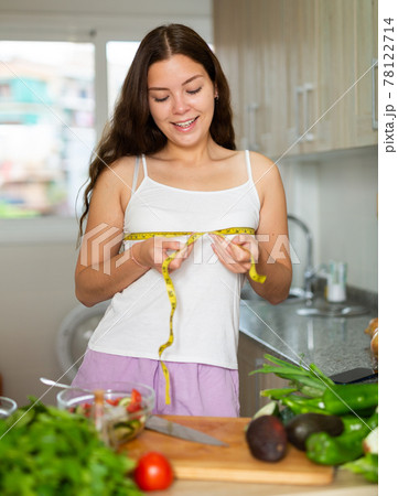 Young cheerful woman taking measurements of body Young cheerful woman taking measurements of body 78122714